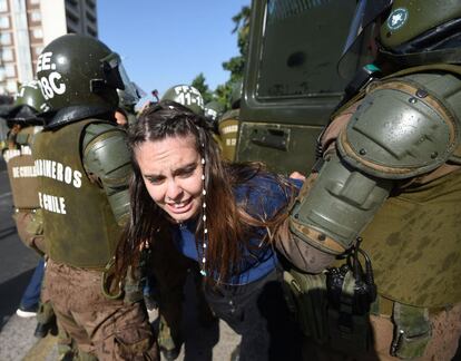 Las fuerzas de seguridad chilenas se llevan a una joven detenida tras las protestas contra la visita del papa Francisco en Santiago de Chile.