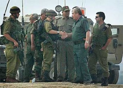 Un militar israelí estrecha la mano a un oficial policial palestino en el cruce de Netzarim, en Gaza.