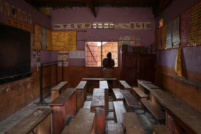 Una maestra se asoma a la ventana de un aula vacía en la escuela de primaria God's Will, en Kampala, cerrada después de la muerte de un niño, el pasado 27 de octubre.