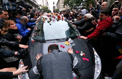 Un fan abraza el coche fúnebre del músico Gustavo Cerati en Buenos Aires (Argentina).