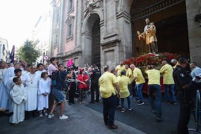 Varios fieles trasladan la imagen de San Cayetano para sacarla en procesión, en Madrid el día 7.