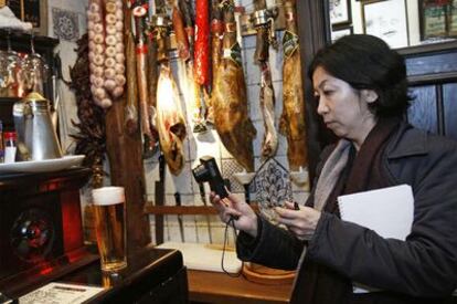 Una periodista japonesa retrata un vaso de cerveza en la taberna La Ardosa.
