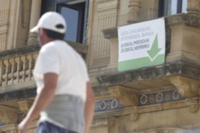 Un hombre pasa el pasado septiembre junto al cartel del Ayuntamiento de San Sebastián en favor de los presos