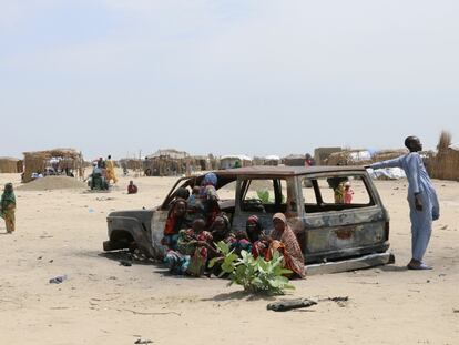 Jóvenes en Diameron, en el Lago Chad, junto a un coche quemado.