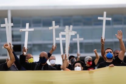 Manifestantes carregam cruzes em protesto contra o presidente Jair Bolsonaro, nesta sexta.