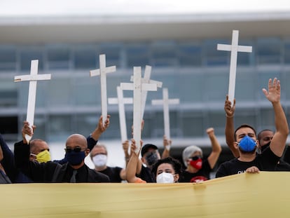 Manifestantes carregam cruzes em protesto contra o presidente Jair Bolsonaro, nesta sexta.