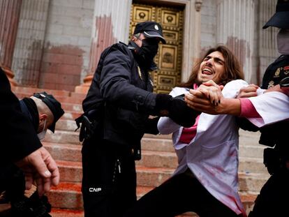 Police officers try to prevent Scientist Rebellion activists from throwing red paint at the exterior of the Spanish Parliament to protest climate change, in Madrid, Spain, April 6, 2022. REUTERS/Susana Vera