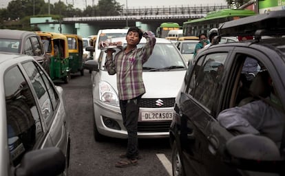 Un niño vende cocos entre los coches en Nueva Delhi (India).