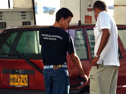 Un trabajador social despacha gasolina en una estación en La Habana.