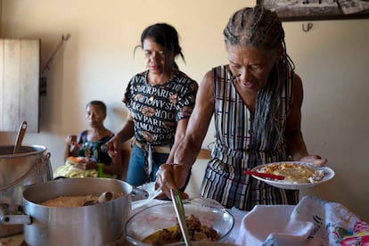 Lucidia María do Socorro dos Santos sirve platos de comida en el quilombo de Tapuio.