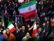 Ciudadanos iraníes ondean banderas durante una manifestación tras el anuncio de un alto el fuego de dos semanas en la plaza Enghelab de Teherán, Irán