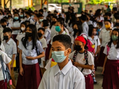 Los estudiantes filipinos esperan en fila para ingresar a sus aulas en el patio de una escuela después de que comience la educación presencial en las escuelas públicas de Manila, Filipinas, el 22 de agosto de 2022.