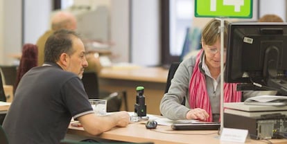 Una trabajadora pública atiende a un ciudadano en una oficina de la Seguridad Social, en una foto de archivo.