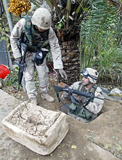 Un soldado estadounidense entra en el agujero donde fue capturado Sadam.