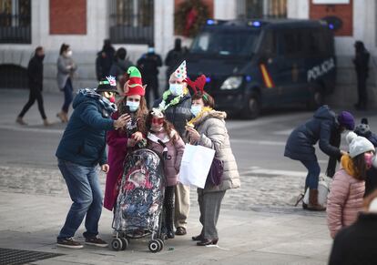 Una familia se hace una foto en la Puerta del Sol, en Madrid (España), el 30 de diciembre de 2020.