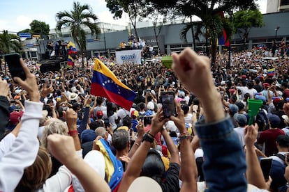 Un manifestante alza el puño al pasar los opositores González y Machado.