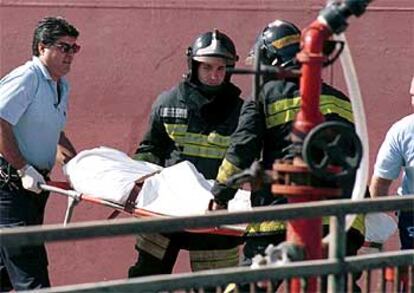 Los bomberos trasladan el cadáver de una de las víctimas del petrolero <b></b><i>Front Lord</i>.