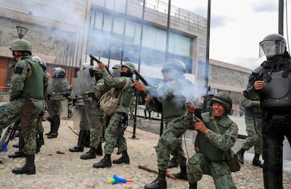 Las fuerzas de seguridad apuntan con sus armas durante una protesta contra las medidas de austeridad del presidente.