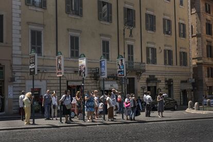 Personas esperando los autobús en el centro de Roma