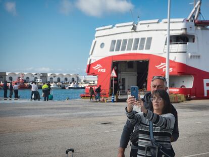 Dos pasajeros se hacen un selfi delante del barco que les llevará hasta Tánger, este jueves.