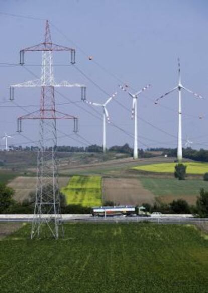 Tendido el&eacute;ctrico con aerogeneradores e&oacute;licos de fondo. 