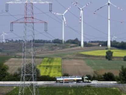 Tendido el&eacute;ctrico con aerogeneradores e&oacute;licos de fondo. 