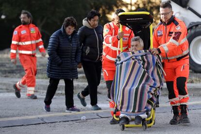 Una superviviente del terremoto es transportada en silla de ruedas por el campamento temporal, en Pescara del Tronto. 