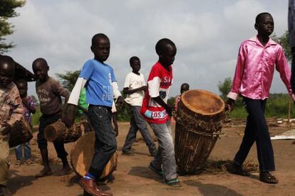 Los niños llevan los tambores para el servicio dominical de la iglesia del campo de refugiados de Gorom.