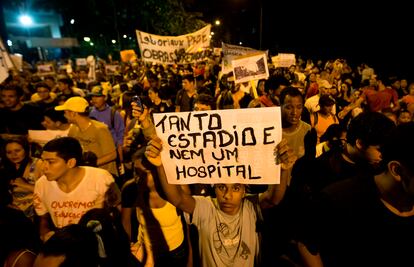 Un joven lleva un letrero que lee 'Tantos estadios y ni un solo hospital', el 25 de junio frente a la casa del entonces gobernador de Río de Janeiro, Sergio Cabral.