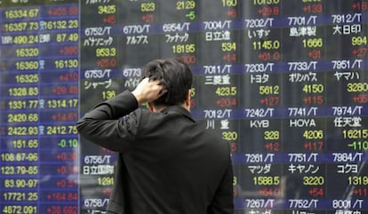 Un hombre observa una pantalla que muestra informaci&oacute;n burs&aacute;til en Tokio (Jap&oacute;n). 