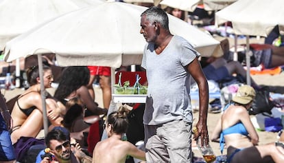 A man sells mojitos on Barcelona's Barceloneta beach.