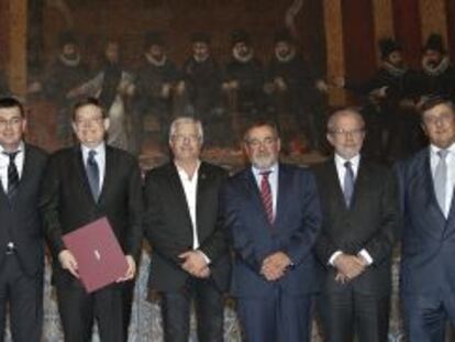 El presidente la Generalitat, en el centro con el acuerdo, posa con los rectores, los representantes de los agentes sociales y el presidente de las Cortes. 