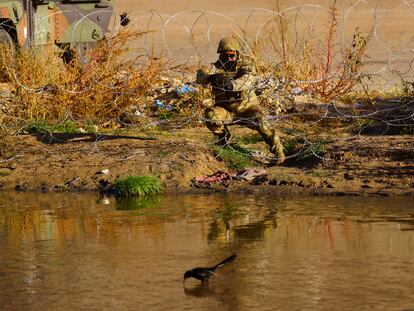 Un miembro de la Guardia Nacional de Texas coloca alambre de púas a orillas del río Bravo, frontera entre Estados Unidos y México.