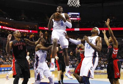 Biyombo, de los Bobcats, atrapa un rebote ante varios jugadores de Toronto Raptors