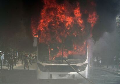 El mismo autobús, ardiendo en el centro de Santiago.