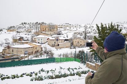 Un hombre fotografía el pueblo alavés de Caicedo-Yuso tras la intensa nevada caída en la provincia de Álava, el sábado.