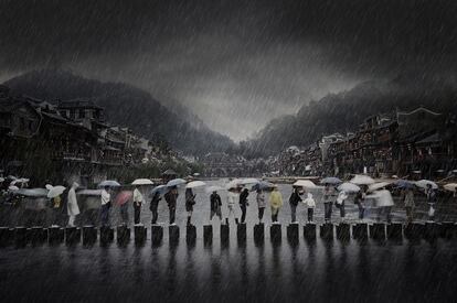 'Rain in Ancient Town'. Esta imagen del fotógrafo chino Chen Li, tomada en el sur de China, muestra la gente viajando durante la temporada de lluvias y es la imagen ganadora en la categoría de Viajes.