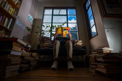 Un joven lee una revista cultural en la librería Merlín en el centro de Bogotá,  el 16 de diciembre de 2022.