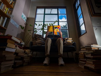 Un joven lee una revista cultural en la librería Merlín en el centro de Bogotá, el 16 de diciembre de 2022.