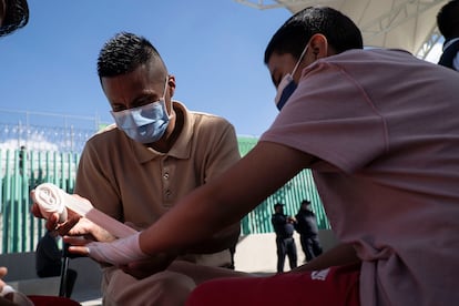 Un interno enseña a su hijo cómo ponerse bandas para boxear.