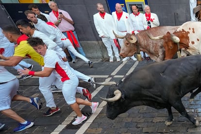 Los mozos son perseguidos por toros de Miura en el tramo de Mercaderes, este lunes.