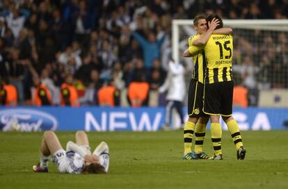 Modric, tirado en el suelo llorando, mientras Hummels celebra con un compañero la victoria del Borussia.