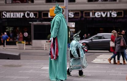 Dos hombres disfrazados de Estatua de la Libertad buscan turistas para fotografiarse con ellos en Time Square, Nueva York, EE UU.