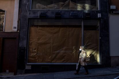Una mujer pasa por delante de un local comercial cerrado en el casco histórico de Toledo, este martes.