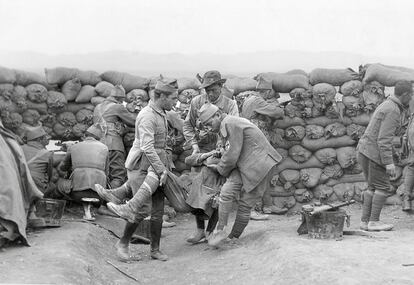 Unos soldados trasladan a un compañero herido mientras el resto de la unidad se defiende de los rifeños tras una muralla de sacos de arena (Marruecos, 3 de octubre de 1921).