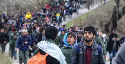 Un grupo de refugiados tratan de encontrar una vía alternativa para cruzar la frontera entre Grecia y Macedonia, este lunes.