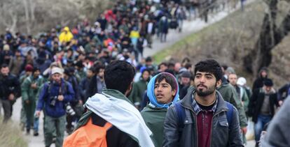 Un grupo de refugiados tratan de encontrar una v&iacute;a alternativa para cruzar la frontera entre Grecia y Macedonia, este lunes.