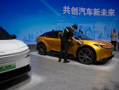 Un trabajador limpia un Toyota bZ 3C en el Salón Internacional del Automóvil de Pekín 2024.