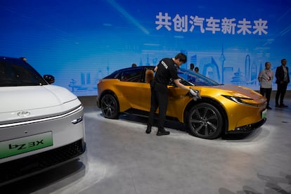 Un trabajador limpia un Toyota bZ 3C en el Salón Internacional del Automóvil de Pekín 2024.