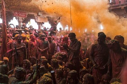 Devotos hindúes arrojan polvos de colores durante las celebraciones de Lathmar Holi, el festival primaveral de los colores en un templo en el pueblo de Barsana del Estado indio de Uttar Pradesh.